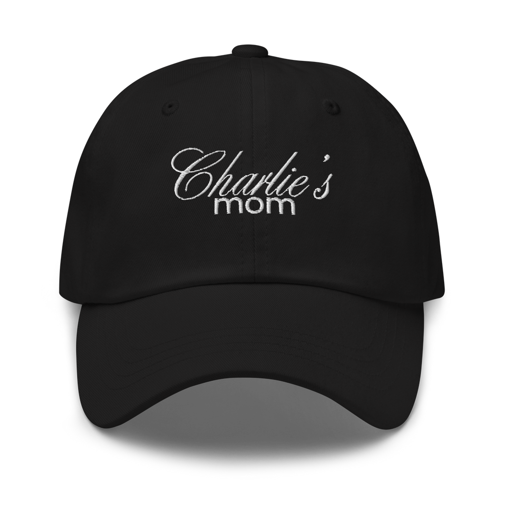 Black baseball cap featuring white embroidered text Charlie's mom in a decorative script font above a simpler sans-serif font highlighting the fabric texture and stitching details